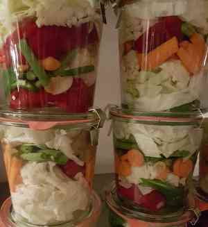 Mélande de légumes lactofermentés présentés dans leur pot en verre
